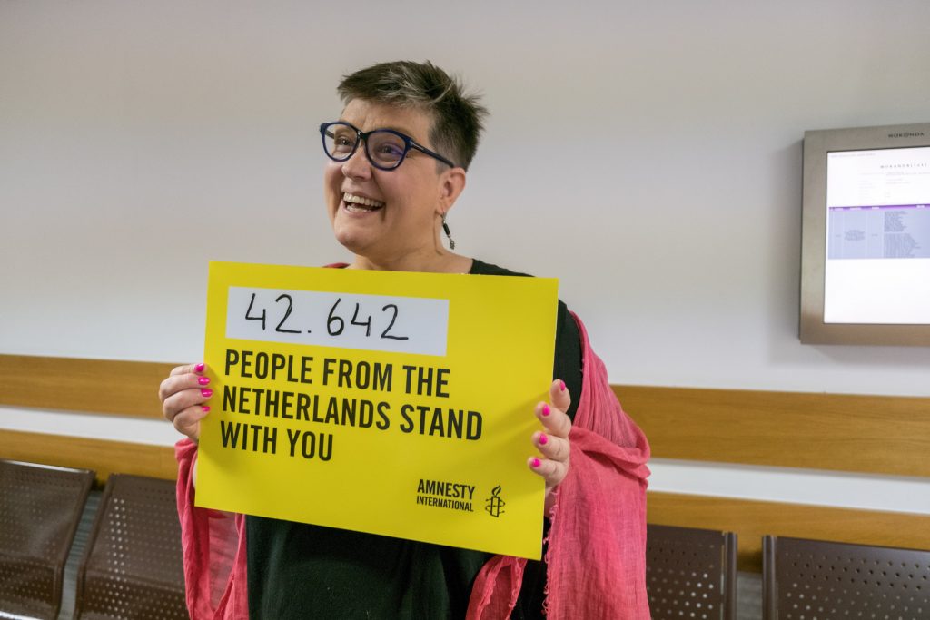 Elżbieta Podleśna in de rechtbank in Warschau in 2019, met een poster waarop het aantal steunbetuigingen uit Nederland staat vermeld. Ze werd met 13 andere vrouwen gehoord over hun rol in een demonstratie.