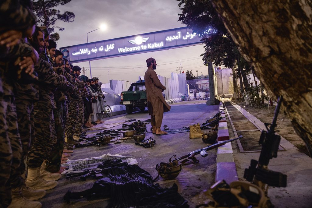 Afghaanse militairen die het vliegveld van Kabul beschermen tijdens het avondgebed eind augustus 2021.