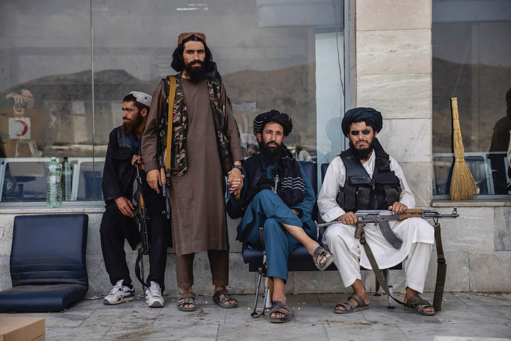 Taliban-strijders rusten uit bij het vliegveld van Kabul na het vertrek van de Amerikaanse troepen, 31 augustus 2021.
