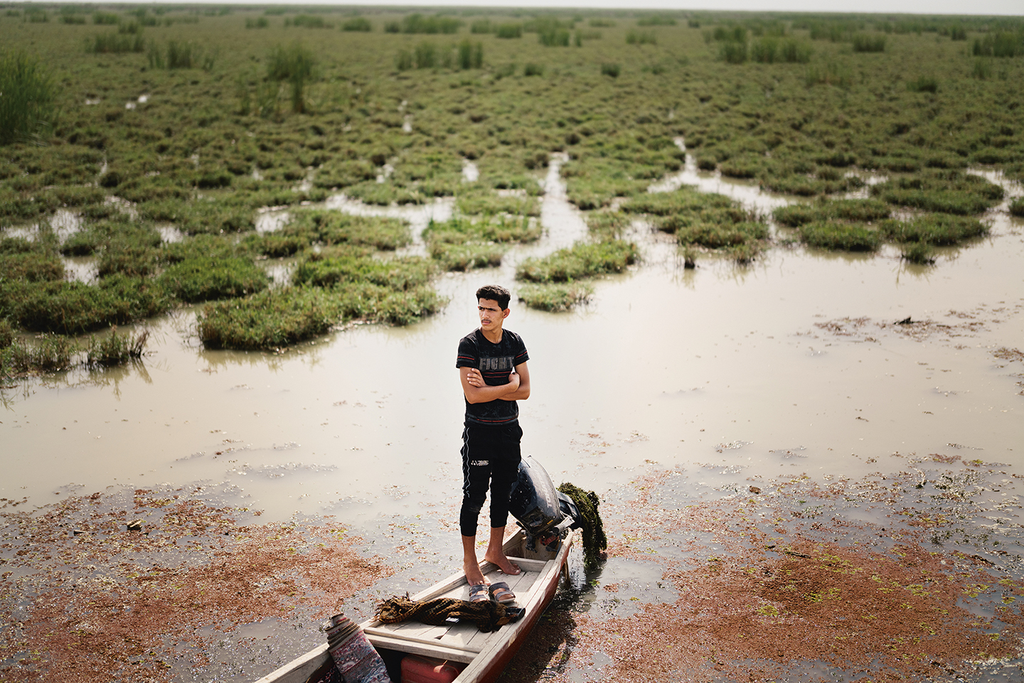 Een herder vaart naar zijn waterbuffelkudde over de sterk veranderde Hawizeh moerassen.