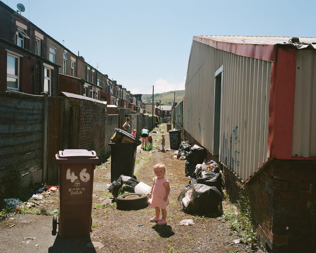 Pennie, het dochtertje van Mark en zijn partner Emma, in de steeg achter hun huis. (Uit de serie Thatcher's Children)