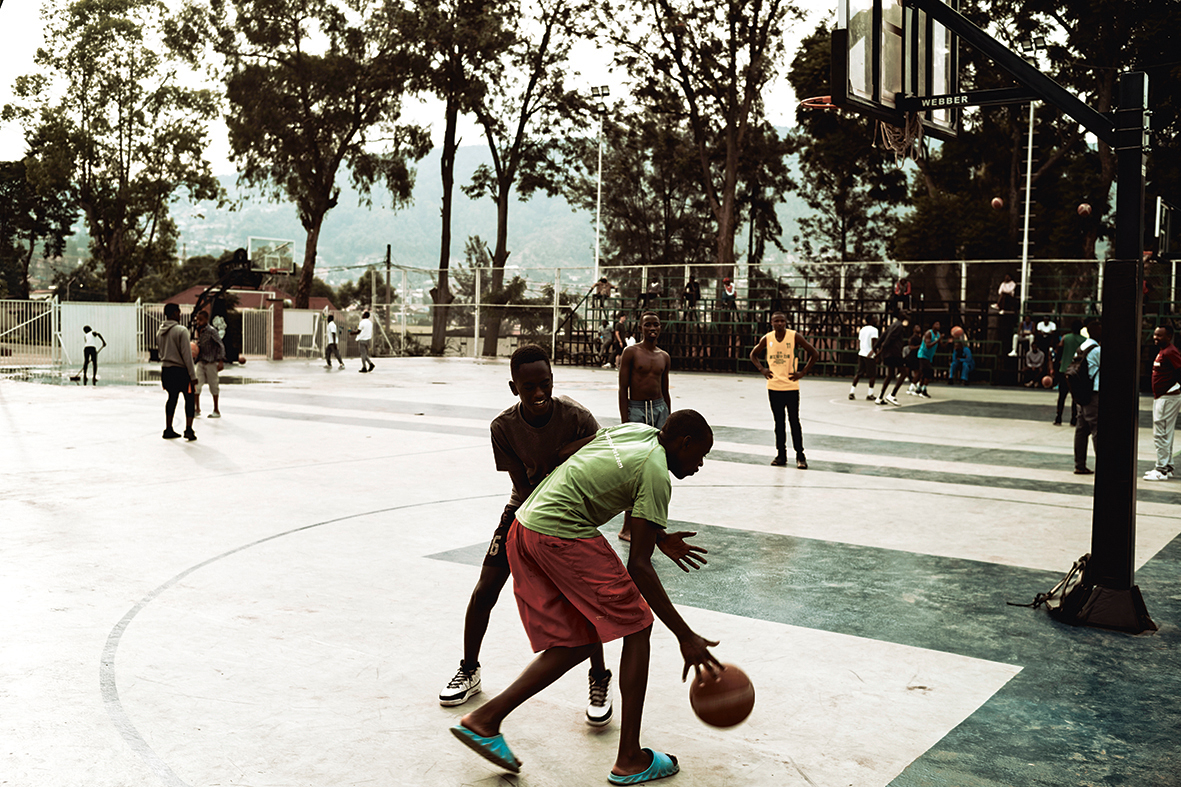 Jongeren basketballen op het speelveld van Club Rafiki in Kigali.