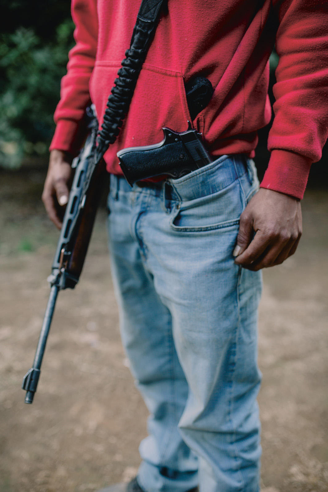 Een zwaarbewapend lid van Pueblos Unidos bewaakt een avocadoveld. De Pueblos Unidos noemen zich een zelfverdedigingsgroep, maar ze hebben banden met de drugkartels en zijn betrokken bij de lucratieve handel in avocado’s.