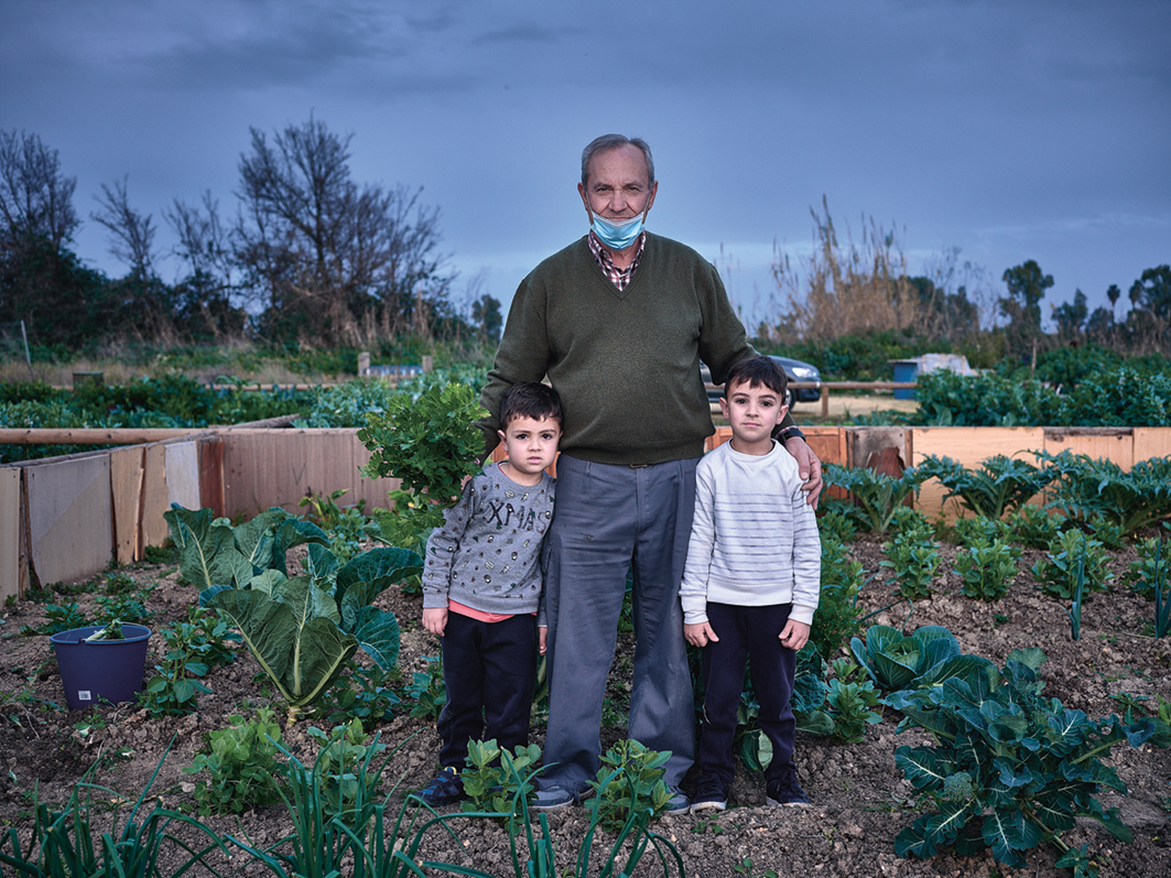 De gepensioneerde Rafael Fuentes wandelt met zijn kleinkinderen door de openbare tuinen van Puebla del Río. Veel ouderen kwamen hier tijdens de coronalockdowns een luchtje scheppen.
