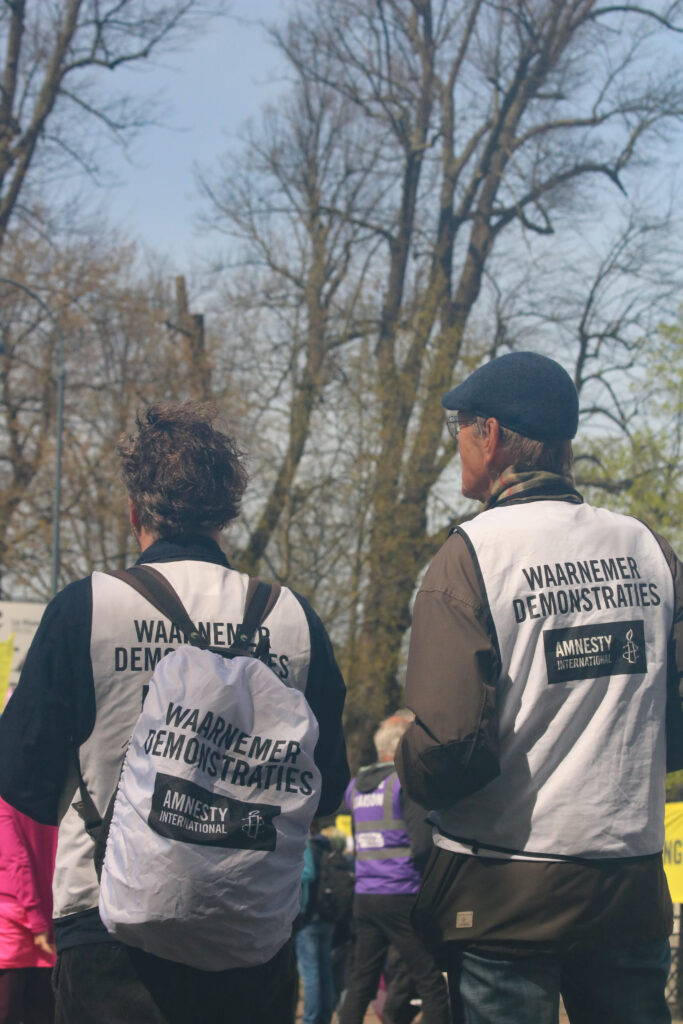 De waarnemers van Amnesty zijn te herkennen aan hun witte hesjes.