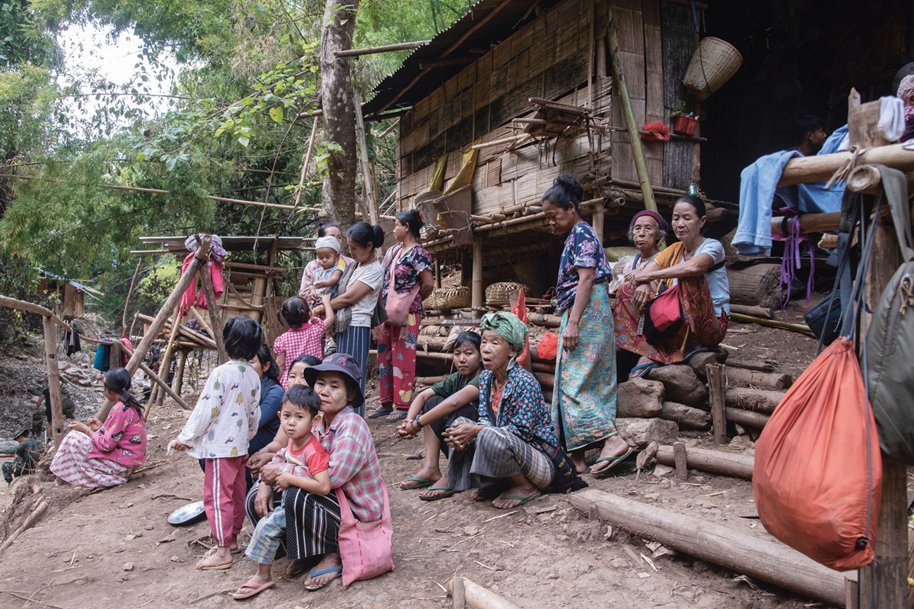 Vluchtelingen die door het geweld van het staatsleger zijn verdreven uit hun dorpen, zitten voor een geïmproviseerd opvanghuis in Karenni.