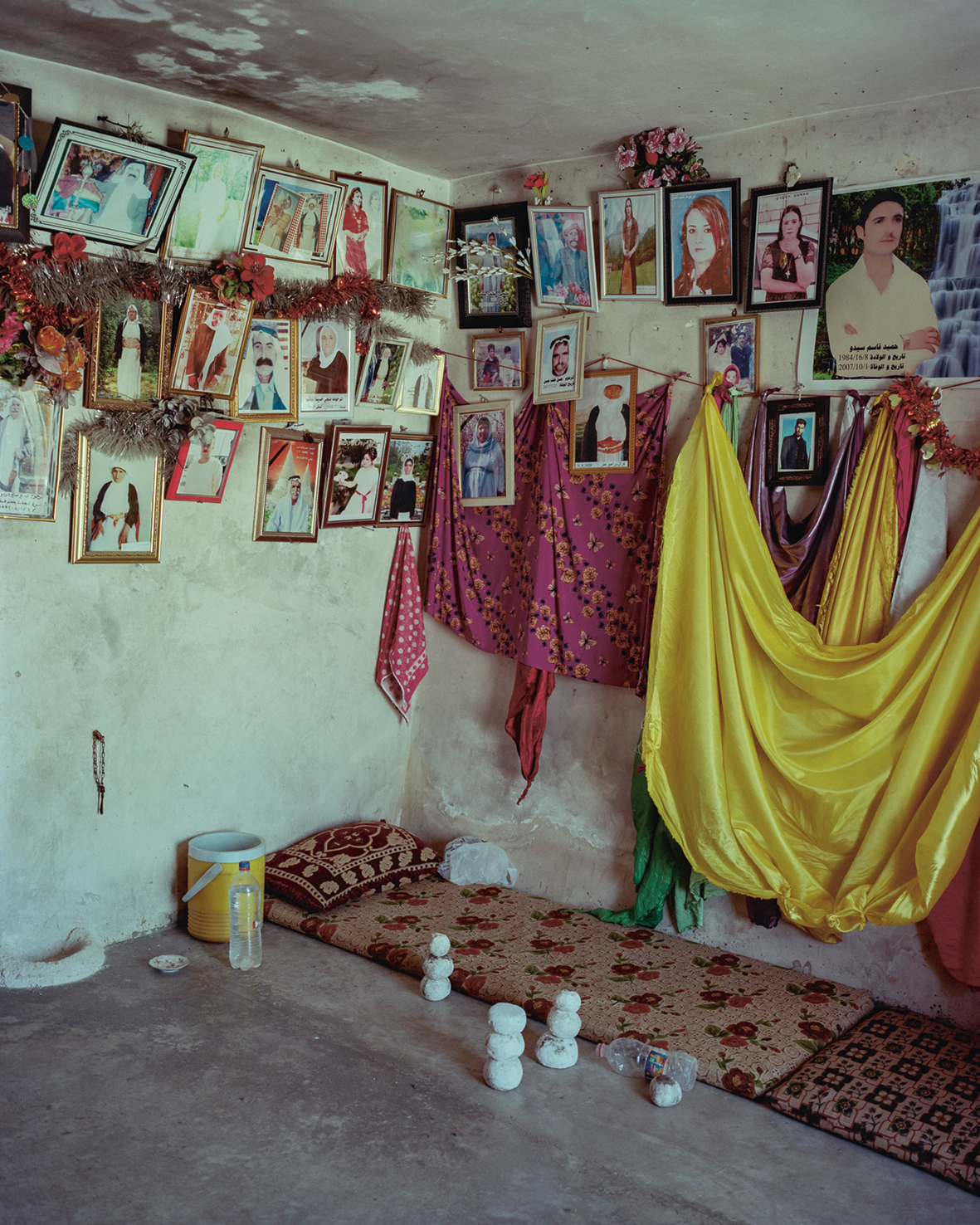 In een Mazar, een Jezidi-heiligdom. Aan de muur hangen enkele kleden en veel foto’s van overledenen. Degene die de kamer betreedt moet de knopen in de kleden losmaken, zodat de geheime wens van degene die de knoop maakte uitkomt. Daarna kan hij zijn eigen knoop maken en een wens doen.