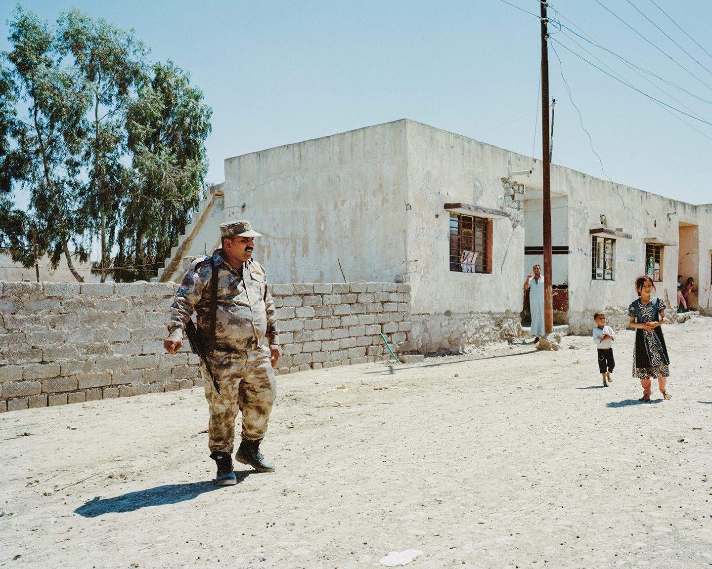 Een Iraakse soldaat patrouilleert door het Arabische dorp Wadi Bir Jari vlak bij de Syrische grens. De inwoners van dit dorp werkten samen met Syrisch-Koerdische troepen, die op hun beurt veel Jezidi’s hebben helpen evacueren.
