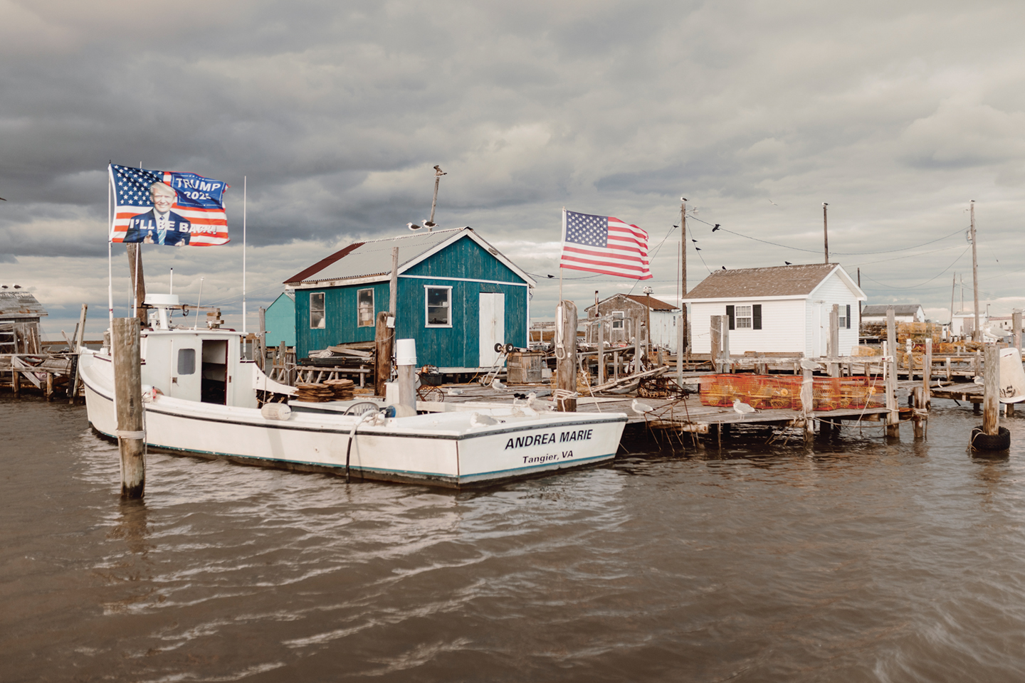 Boven de haven wappert de Amerikaanse vlag met een beelte- nis van Donald Trump. In 2020 stemde 87 procent van de inwoners van het eiland Tangier op Trump.