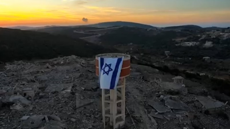 Israëlische vlag op een watertoren in het verwoeste Aita Ash Shaab.