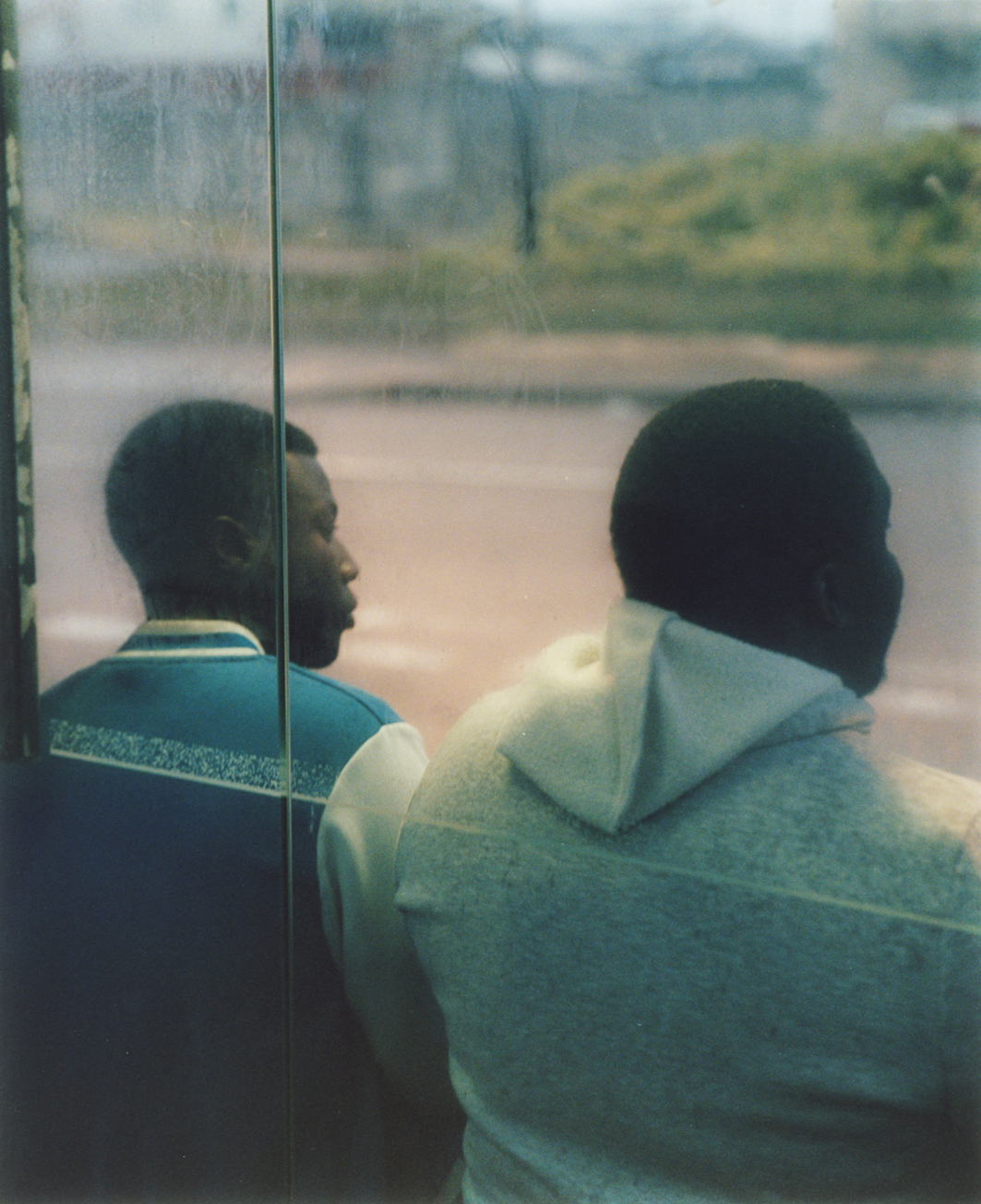 Twee mannen wachten op de shuttlebus die ze terugbrengt naar de Bibby Stockholm.