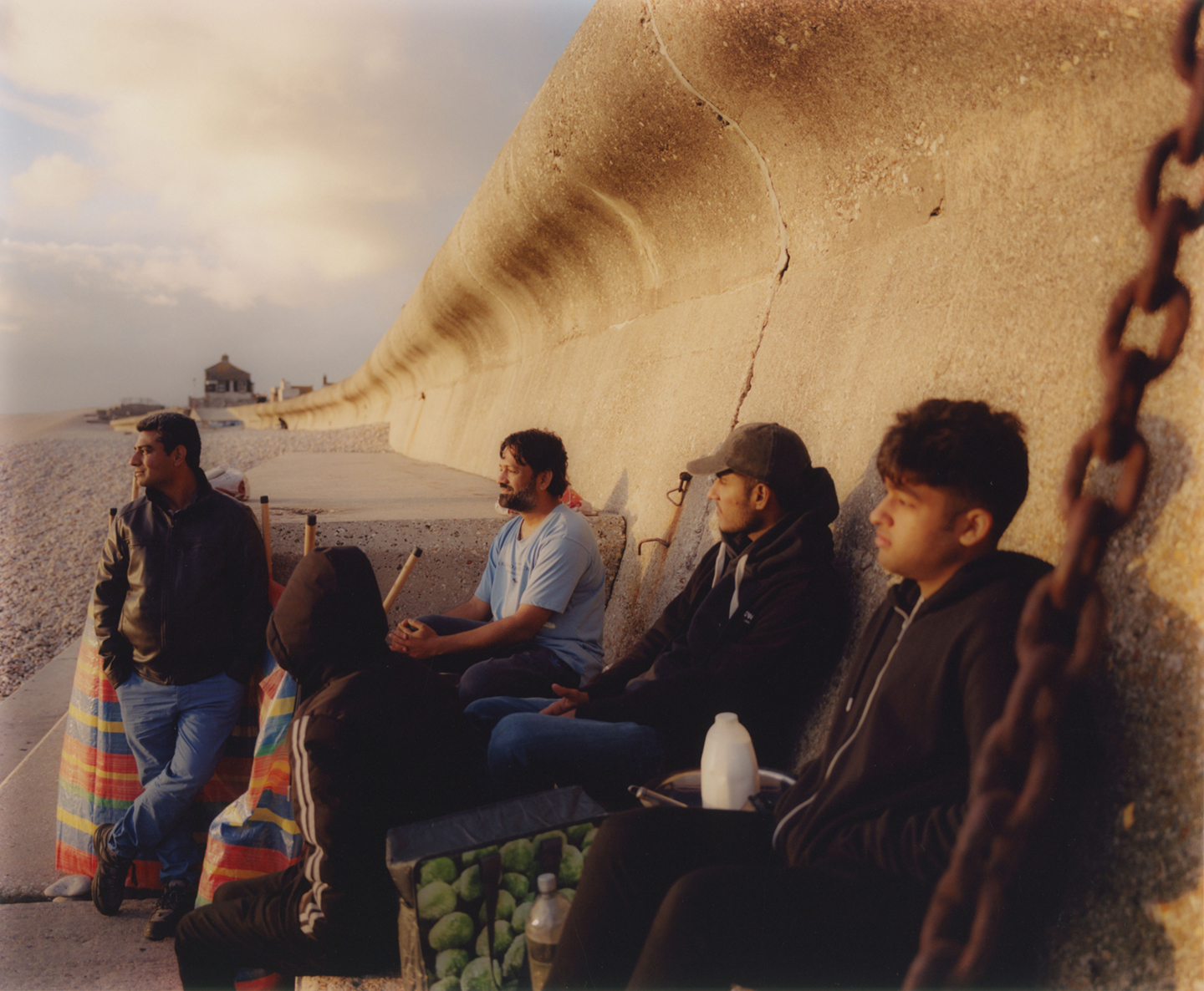 Een groep Pakistaanse mannen bereidt een traditionele kipstoofpot op een open vuur op Chesil Beach. Op de boot hadden ze geen keuken.