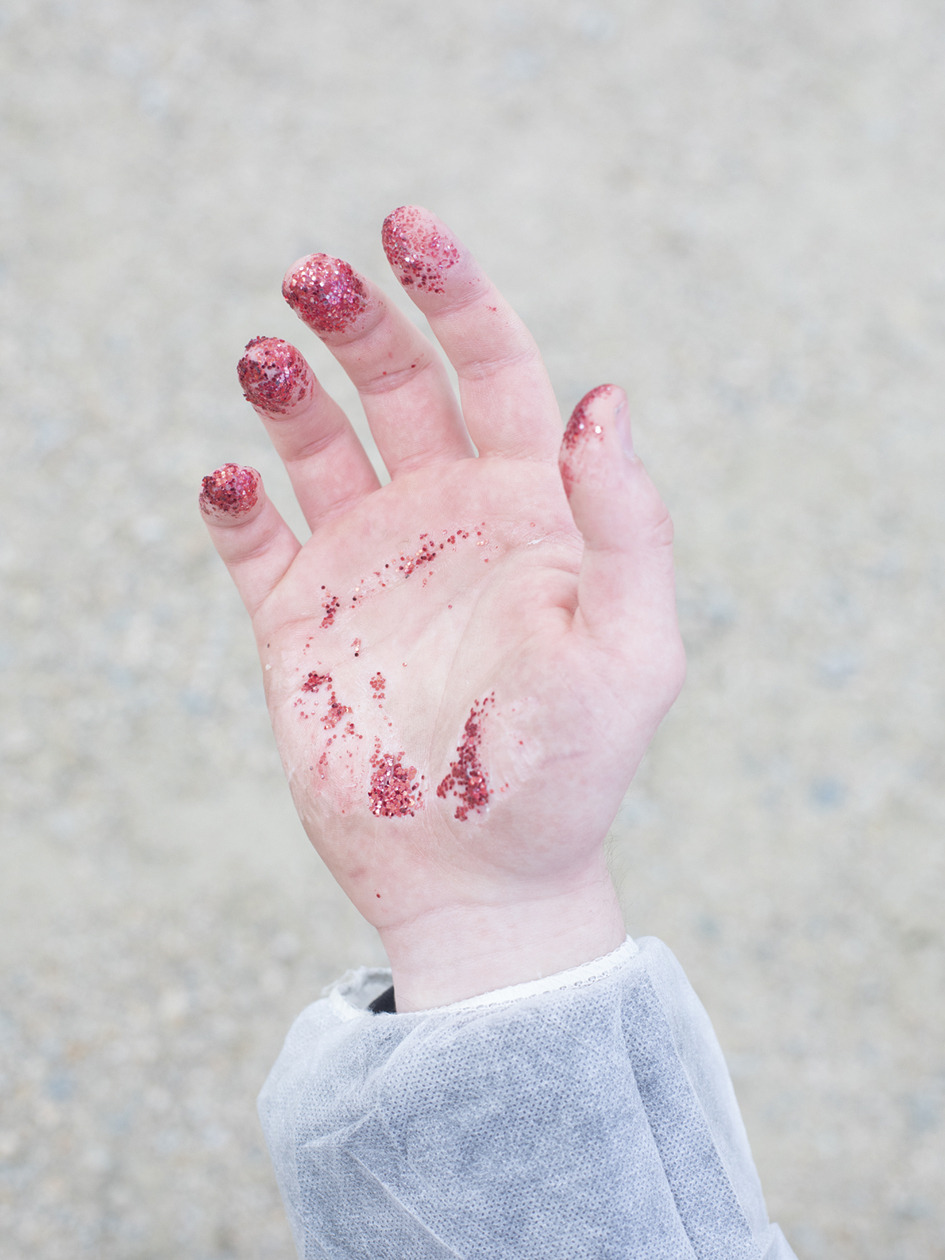 De hand van een activist bedekt met lijm en glitter, zodat de politie geen vingerafdrukken kan nemen.