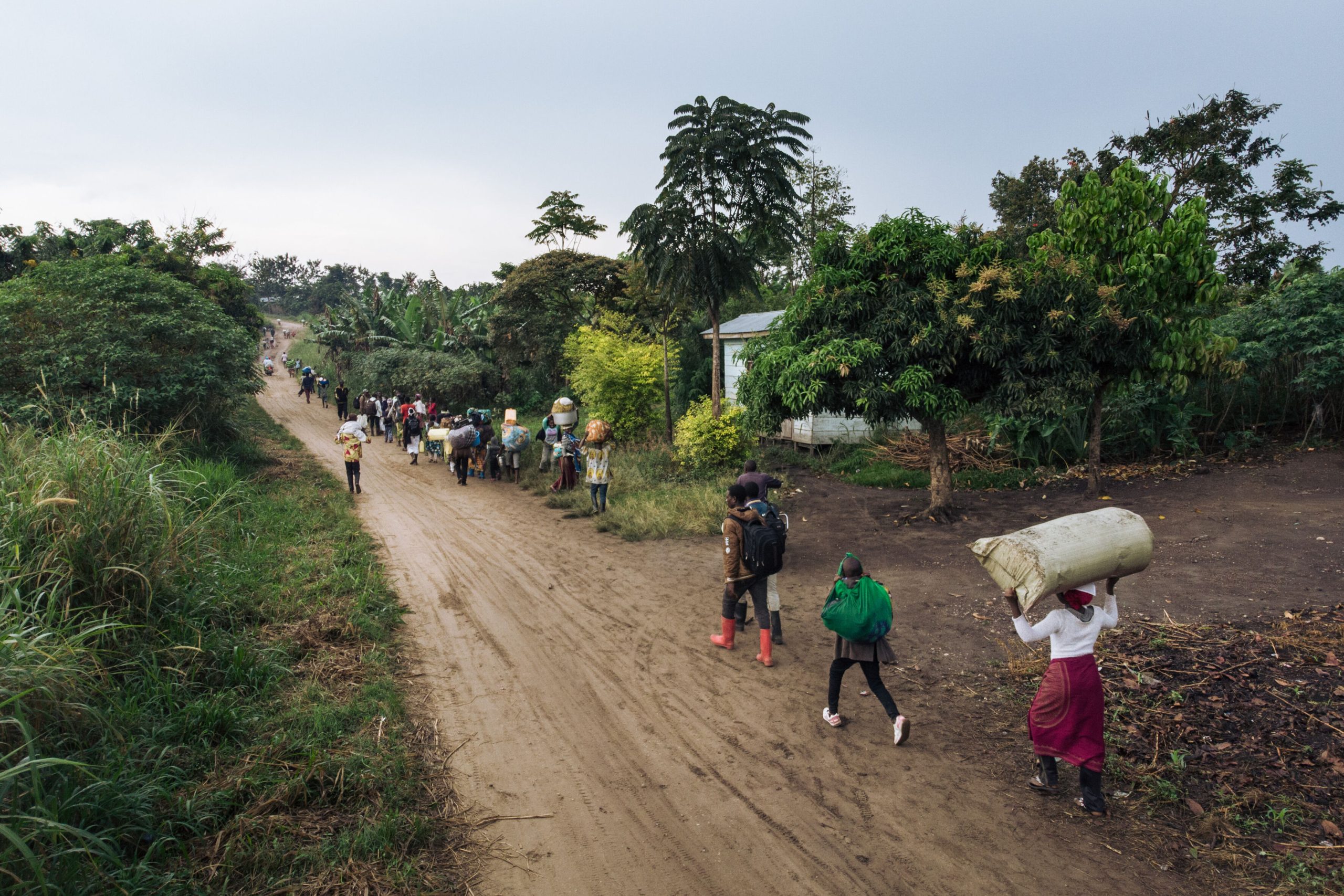 Ontheemden vluchten met hun bezittingen weg van de plaats van een aanval die naar verluidt is gepleegd door de rebellengroep Allied Democratic Forces (ADF) in het dorp Halungupa bij Beni, Oost-Congo, op 18 februari 2020.(c) Alexis Huguet/AFP via Getty Images